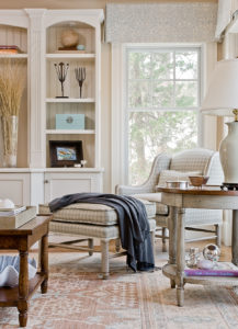 Centering on a color palette of blue, gray and cream, Clark transforms the family room into a cozy space, centered by the gingham-print wing chair by Minton-Spidell. 